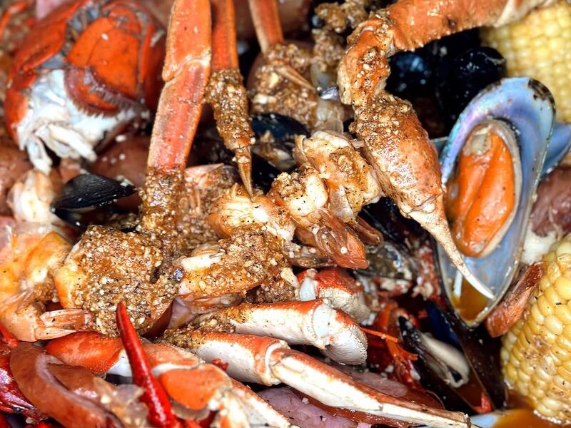 Snow crab legs, mussels, corn and potatoes in a seasoned seafood boil